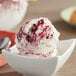 A bowl of blueberry ice cream with a spoon.