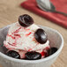 A bowl of ice cream with Oringer Black Cherry Halves in a bowl.