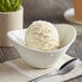 A bowl of Oringer cheesecake ice cream on a napkin with a spoon.