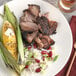 A white plate with rice, beans, and meat topped with McCormick Culinary Caribbean Jerk Seasoning.