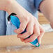 A person using a blue Klever Kutter to cut a box.