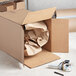 A Lavex cardboard shipping box with crumpled paper inside.