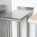 An Advance Tabco stainless steel filler table with legs.