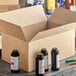 An open Lavex Kraft shipping box filled with several bottles of paint.