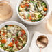 Two bowls of soup with McCormick Italian Seasoning, noodles, and vegetables.