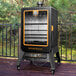 A black and orange Pit Boss Sportsman 5 Series vertical pellet smoker on a deck.