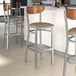 Lancaster Table & Seating bar stools with taupe vinyl seats and wood backs.