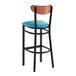 A bar stool with a black metal frame, blue vinyl seat, and an antique walnut wood backrest.