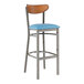 A Lancaster Table & Seating bar stool with a blue vinyl seat and wood back.