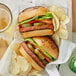 Two Before the Butcher plant-based burgers with chips on a table.