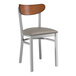 A Lancaster Table & Seating Boomerang chair with a dark gray vinyl seat and wooden back.