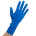 A hand wearing a blue High Risk Latex glove.