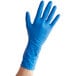 A hand wearing a blue high risk latex glove.