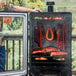 A man standing next to a Pit Boss Sportsman 7 Series vertical pellet smoker with meat inside.