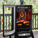 A Pit Boss Sportsman 7 Series vertical pellet smoker on an outdoor patio with meat and vegetables inside.