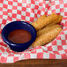 A navy blue Thunder Group smooth melamine ramekin filled with sauce next to fried mozzarella sticks.