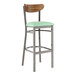 A Lancaster Table & Seating bar stool with a seafoam vinyl seat and vintage wood back.