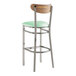 A Lancaster Table & Seating bar stool with a seafoam vinyl seat and vintage wood back and chrome legs.