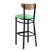 A black bar stool with a seafoam vinyl seat and a curved vintage wood backrest.