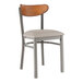 A Lancaster Table & Seating Boomerang chair with a light gray vinyl seat and antique walnut back.