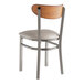 A Lancaster Table & Seating Boomerang chair with a light gray vinyl seat and antique walnut wood back.