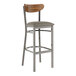 A Lancaster Table & Seating bar stool with a wooden back and gray vinyl seat.
