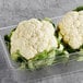 A container of fresh cauliflower heads.