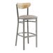 A Lancaster Table & Seating bar stool with a wooden back and grey cushion.