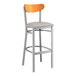 A Lancaster Table & Seating bar stool with a wood back and cushioned seat.