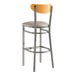 A Lancaster Table & Seating bar stool with a cherry wood back and light gray cushion.