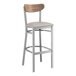 A Lancaster Table & Seating bar stool with a wooden seat and vintage wood back on a white background.