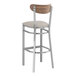 A Lancaster Table & Seating bar stool with a light gray vinyl seat and a wooden back.