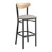 A Lancaster Table & Seating black bar stool with a driftwood back and light gray seat.