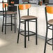 Lancaster Table & Seating Boomerang Series bar stools with taupe vinyl seats and cherry wood backs.