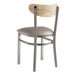 A Lancaster Table & Seating metal and wood chair with a dark gray vinyl seat and driftwood back.