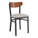 A Lancaster Table & Seating black dining chair with a light gray cushion and wood back.