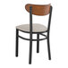 A Lancaster Table & Seating Boomerang Series black wood dining chair with a light gray seat.