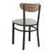 A Lancaster Table & Seating Boomerang Series black wood dining chair with a light gray cushioned seat.