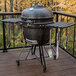 A round black Louisiana Grills K24 ceramic grill on a deck.