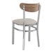 A Lancaster Table & Seating Boomerang wood and metal chair with a light gray cushion.