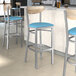 Lancaster Table & Seating Boomerang bar stools with blue vinyl seats and driftwood backs.