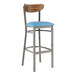 A Lancaster Table & Seating bar stool with a blue vinyl seat and wood back and metal frame.