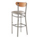A Lancaster Table & Seating bar stool with a wooden back and white cushion.