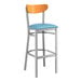 A Lancaster Table & Seating bar stool with a blue vinyl seat and cherry wood back.