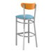 A Lancaster Table & Seating bar stool with a blue vinyl seat and cherry wood back.