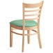 A Lancaster Table & Seating wooden ladder back chair with a seafoam vinyl seat.