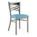 A Lancaster Table & Seating metal cross back chair with a blue vinyl cushion