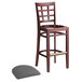 A Lancaster Table & Seating mahogany wood bar stool with a detached dark gray vinyl seat.