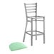 A Lancaster Table & Seating ladder back bar stool with a seafoam vinyl padded seat.