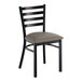 A ladder back chair with a distressed copper finish and a dark gray vinyl padded seat.